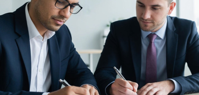 Два человека подписывают документы