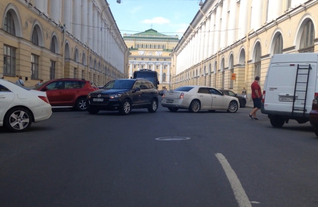 Белый Cadillac , отъезжая от поребрика въехал в тоже отъезжающий, но с другой стороны улицы, Volkswagen Touareg ДТП на улице Зодчего