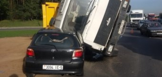 Самосвал с песком опрокинулся правым бортом на кабину легкового автомобиля